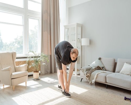 Person doing light stretching in a bright room