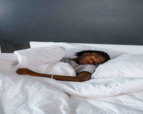 Close up of a person sleeping comfortably in clean bedding